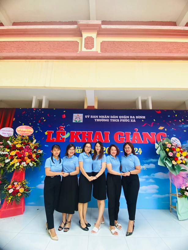 A group of women standing in front of a bannerDescription automatically generated